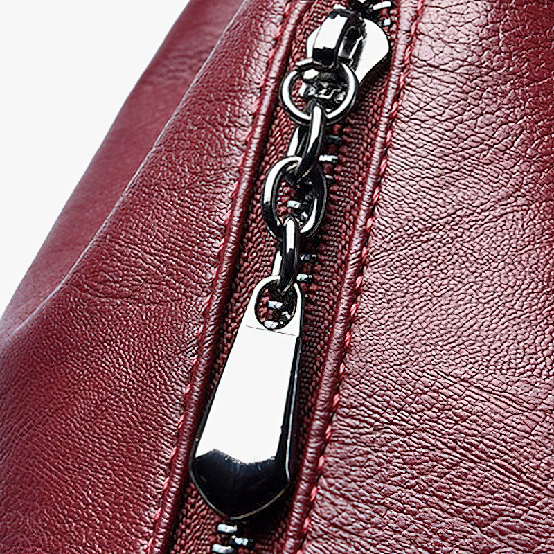 Close-up of a burgundy PU leather bag zipper detail showcasing exquisite design and quality craftsmanship.