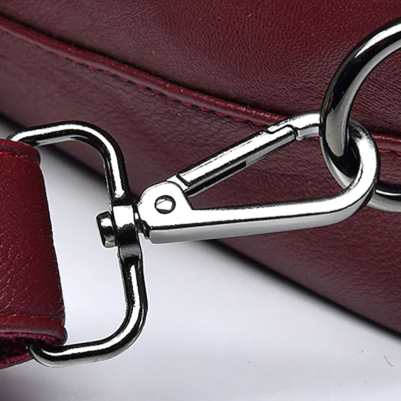 Close-up of the metallic clip on a burgundy PU leather shoulder bag, showcasing its exquisite design and durable functionality.
