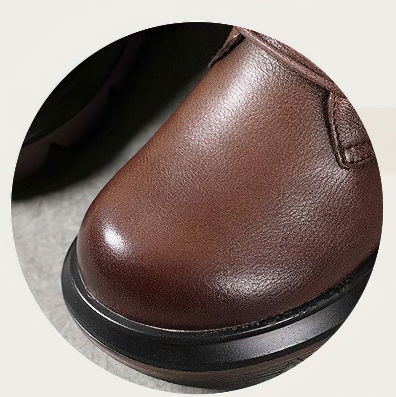 Close-up of women's brown leather boot, showcasing the smooth texture and sturdy rubber sole for stylish comfort.