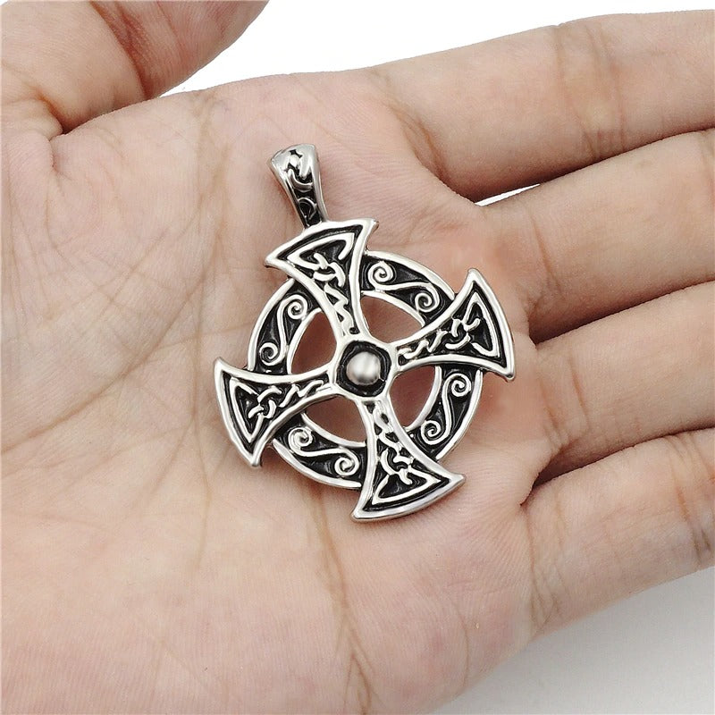 Celtic solar cross pendant necklace in zinc pewter held in hand, perfect for trendy jewelry lovers.