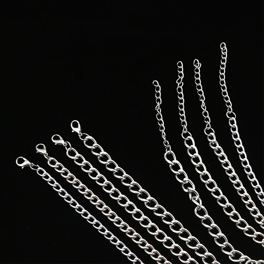 Collection of silver chain links for layered necklaces on a black background, perfect for trendy fashion aesthetics.