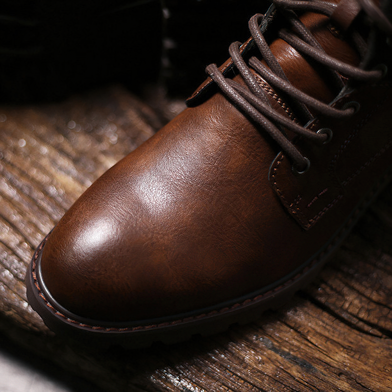 Close-up of brown handmade leather classic ankle boots for men with lace-up design, showcasing their stylish casual appeal.