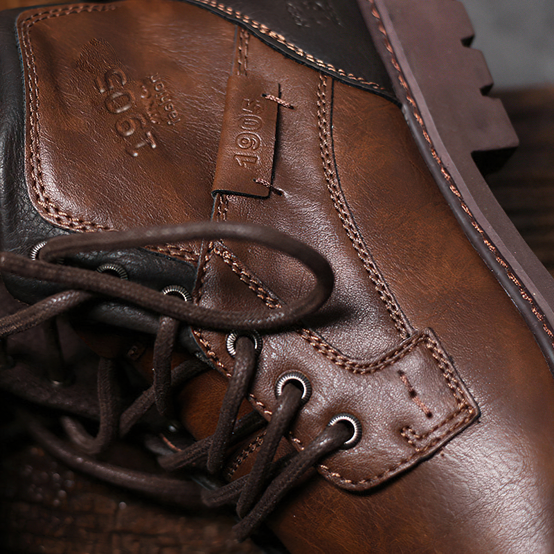 Close-up of classic brown handmade ankle boots for men with lace-up design and waterproof quality.