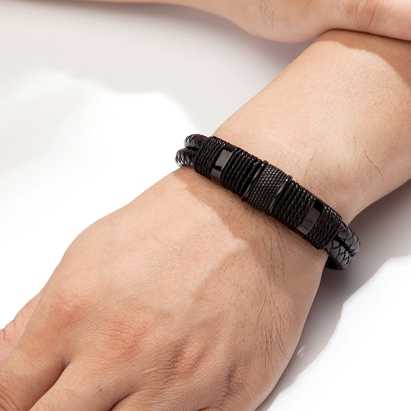 Classic stainless steel men's bracelet on a hand, featuring genuine leather in a stylish black and gold design.
