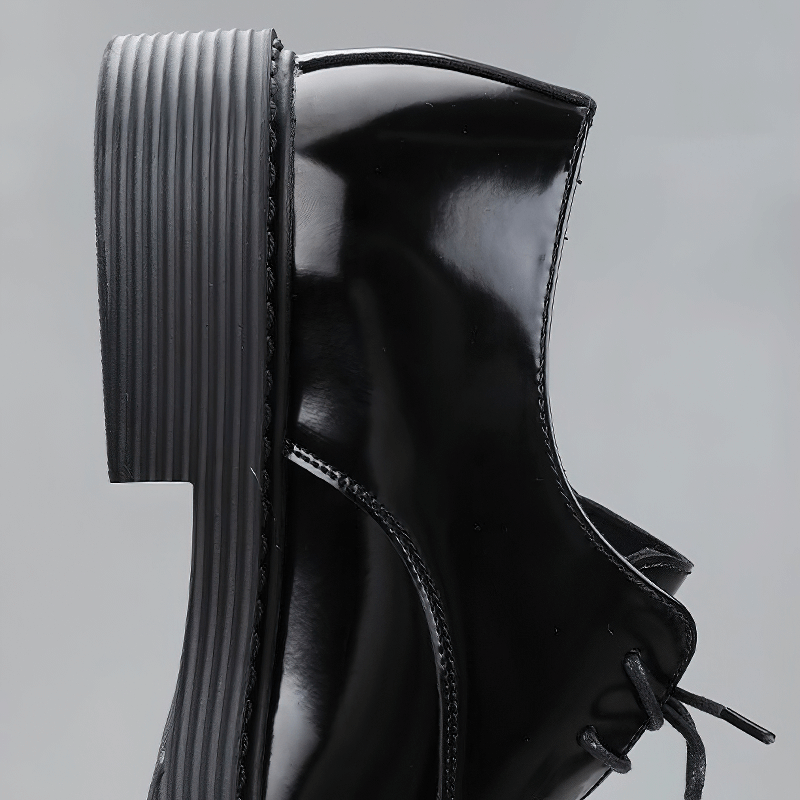 Close-up of the sleek black Derby shoe, showcasing the shiny finish and stylish chunky heel.