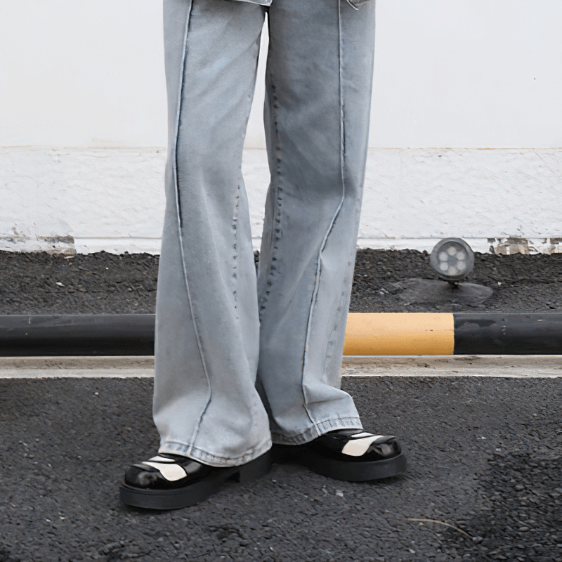 Men's style with retro black and white Derby shoes paired with light gray wide-leg jeans, showcasing a trendy urban look.