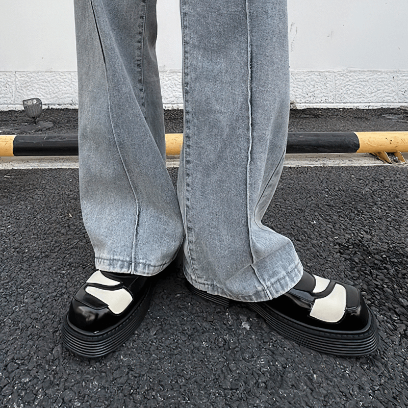Stylish black and white square toe derby shoes for men, paired with relaxed fit jeans.