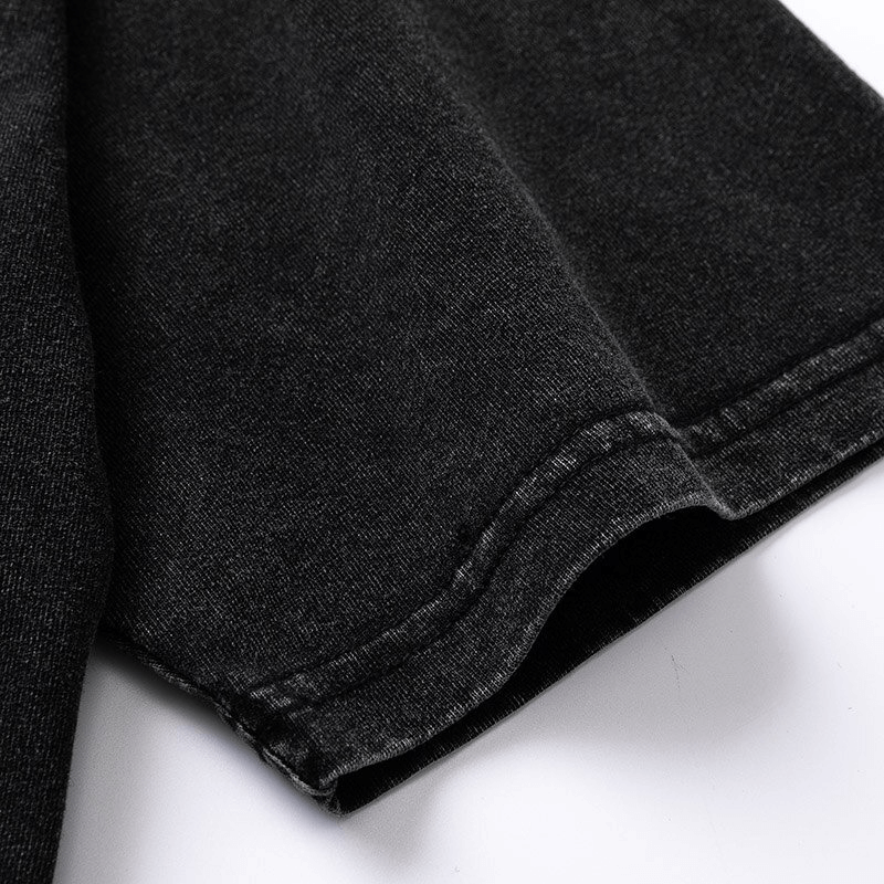 Close-up of the hem and sleeve of a black casual cotton t-shirt, showcasing its quality fabric and stitching details.