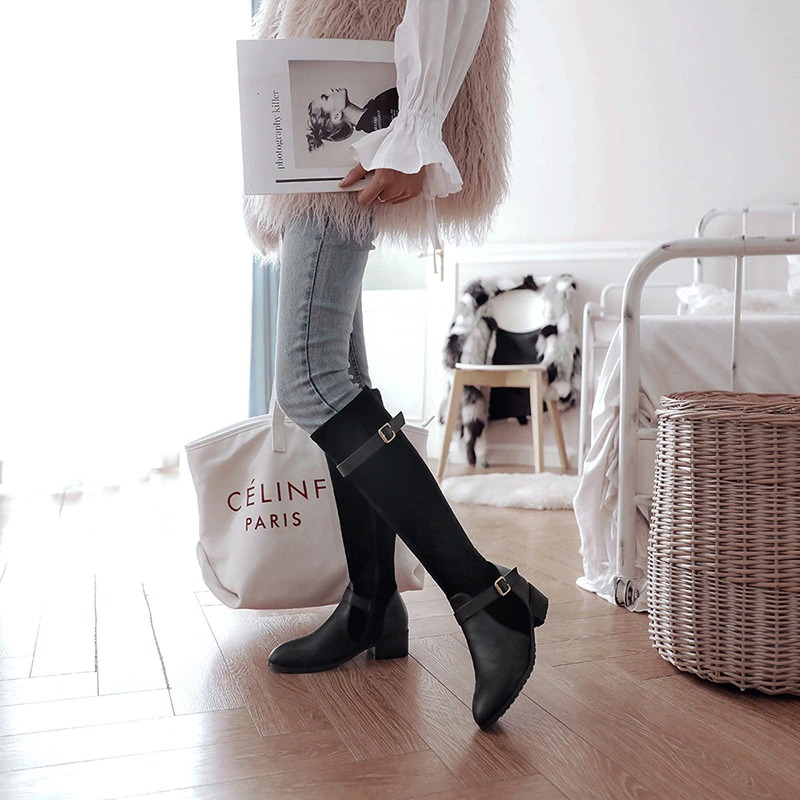 Stylish ladies knee high boots in black PU leather, paired with casual jeans and fashion layers, perfect for everyday wear.