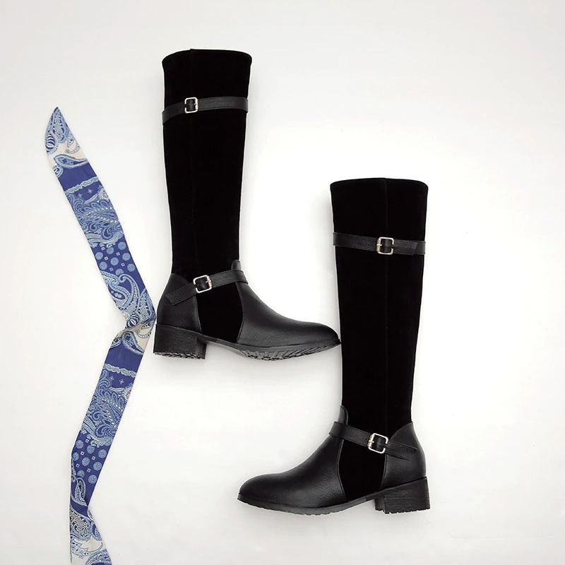 Ladies knee high boots in black leather and suede, featuring a low heel and stylish buckle detail.
