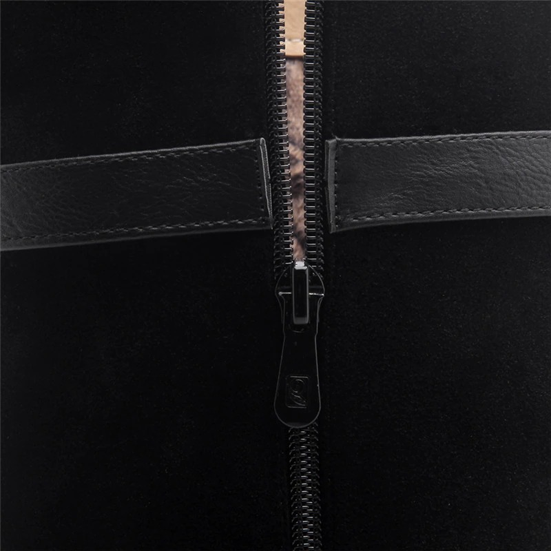 Close-up of the zipper detail on stylish black ladies knee high boots made of suede and PU leather.