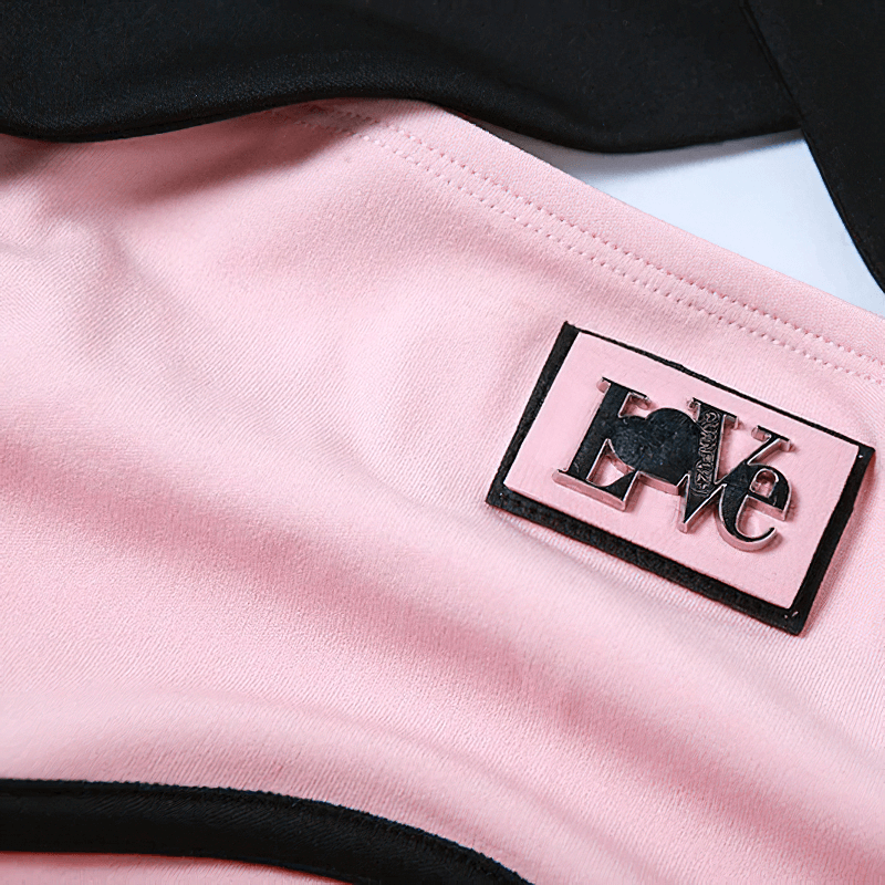 Close-up of a women's halter top featuring a pink and black design with a stylish 'LOVE' logo label.