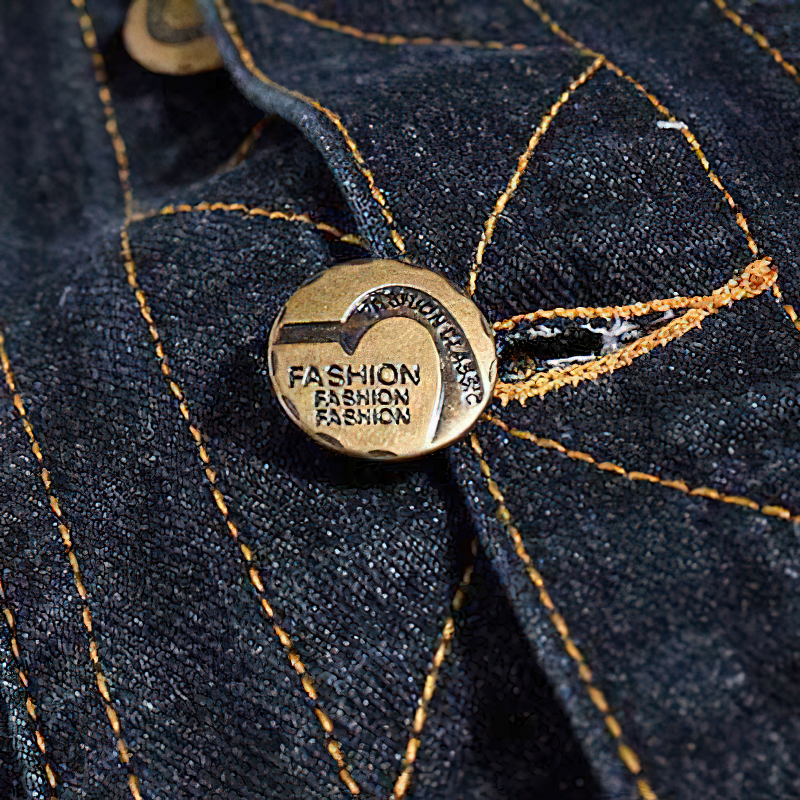 Close-up of a stylish bronze button on a denim vest, showcasing rock aesthetic and fashion details.