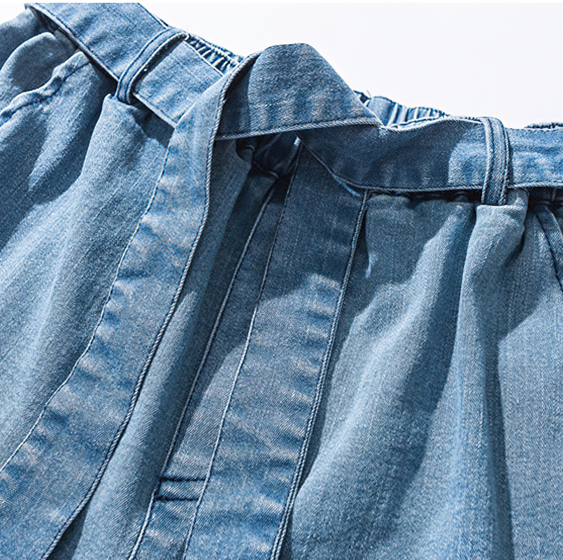 Close-up of cool loose jeans for men, featuring an elastic waist and stylish ribbon detail for a trendy, casual look.