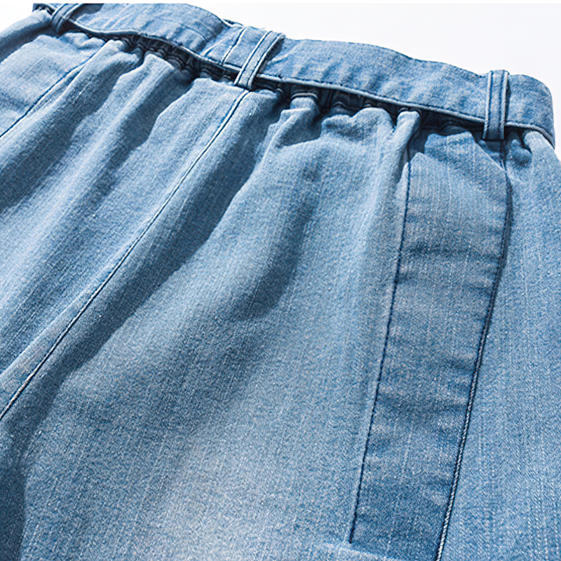 Close-up of elastic waistband on cool loose jeans for men, showcasing retro jogger style and unique fabric texture.