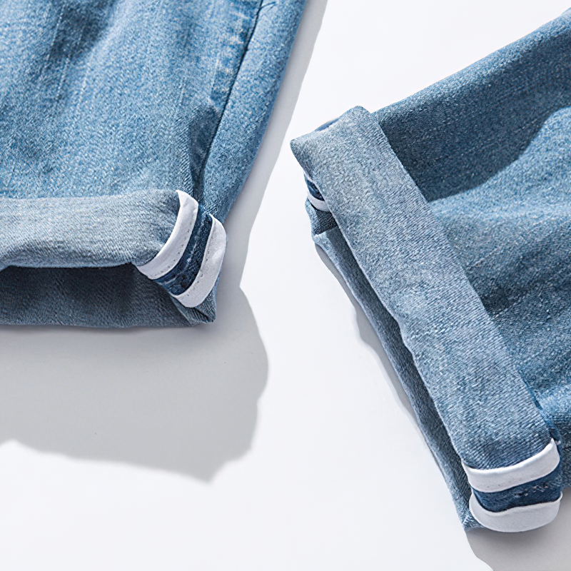 Cuffed hems of cool loose jeans for men, featuring stylish elastic waist and unique ribbon detail.
