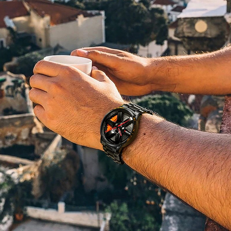 Man's wrist wearing a cool vintage biker stainless steel quartz watch while holding a cup, enjoying the outdoors.