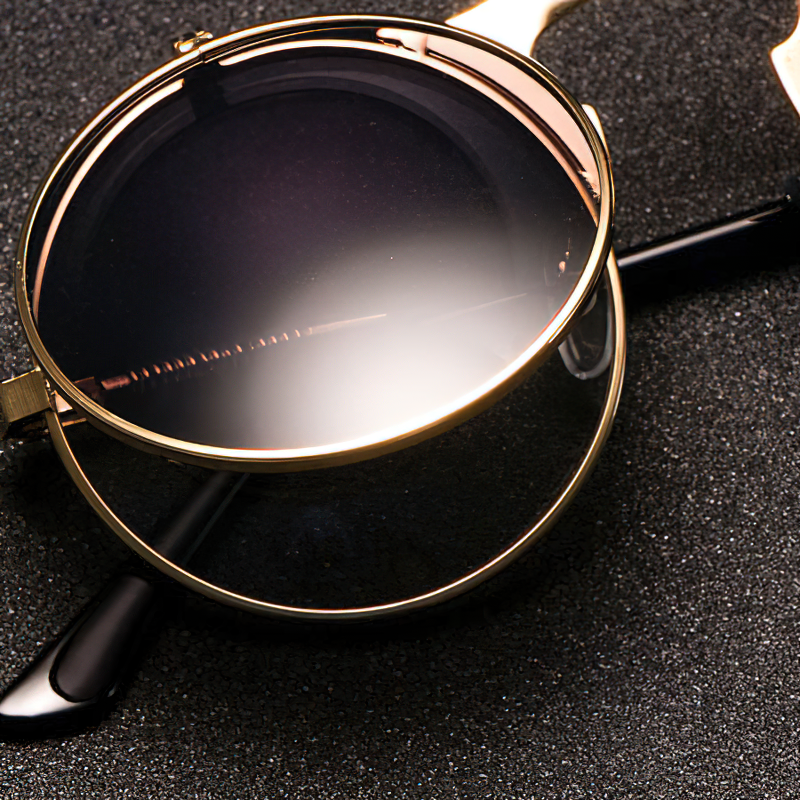 Cool metal round sunglasses with UV protection, perfect for men and women. Stylish retro eyewear on a textured surface.
