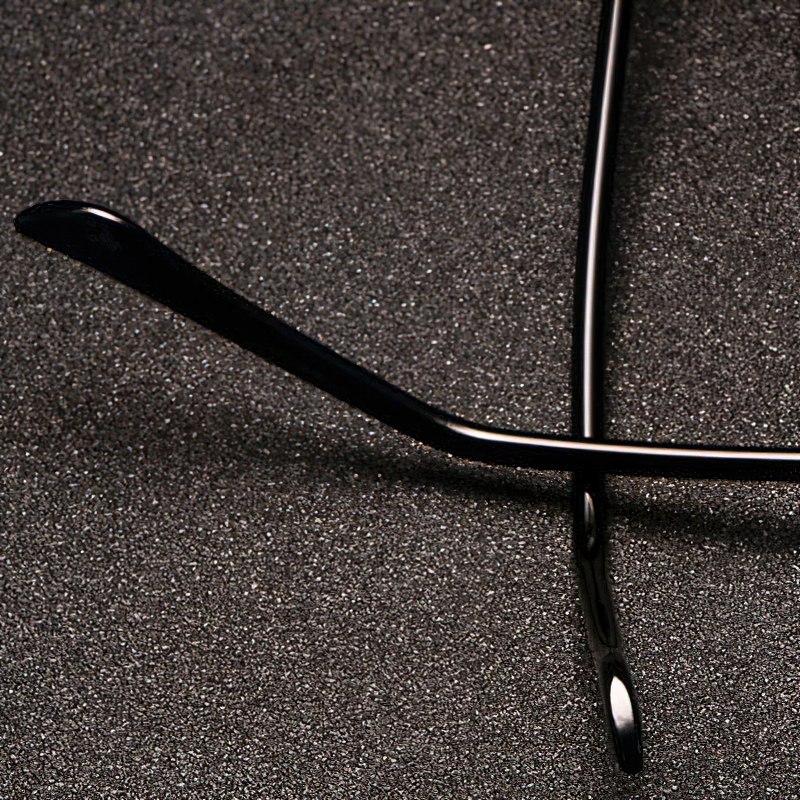 Close-up of stylish metal sunglasses arms on textured background, showcasing unique design and quality craftsmanship.