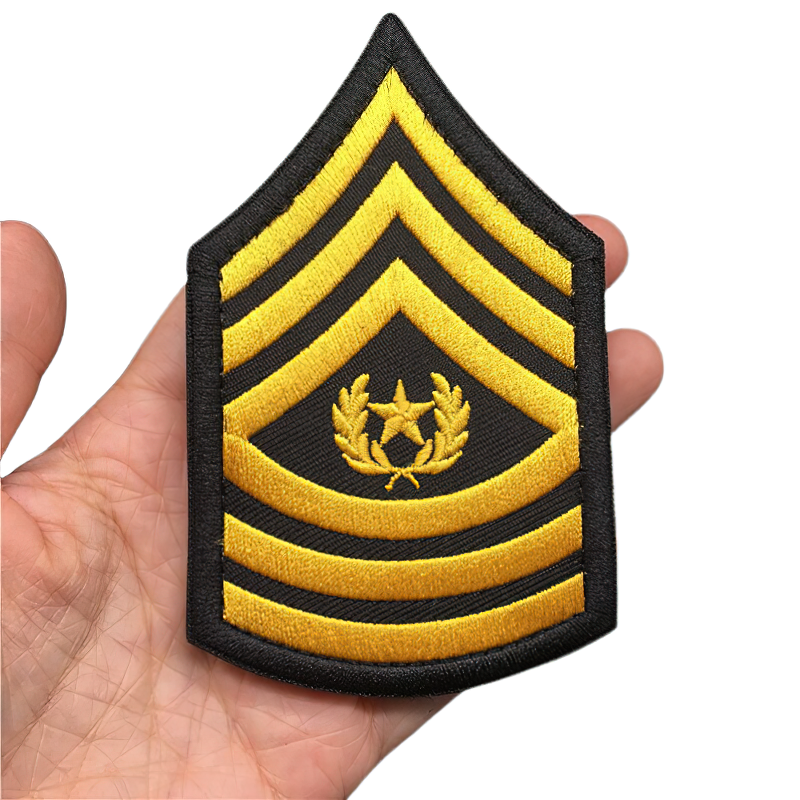Hand holding a cool military embroidered tactical patch with yellow stripes and emblem.