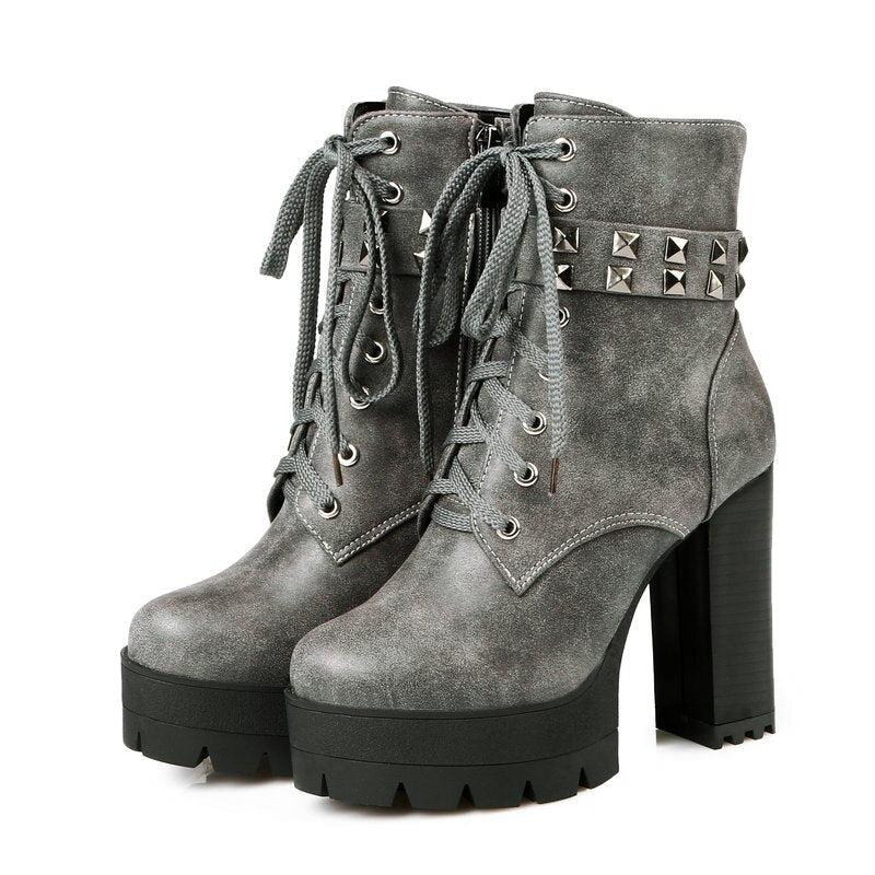 Stylish women's high-heel winter boots in gray, featuring chunky sole, rivets, and laces for a bold biker look.