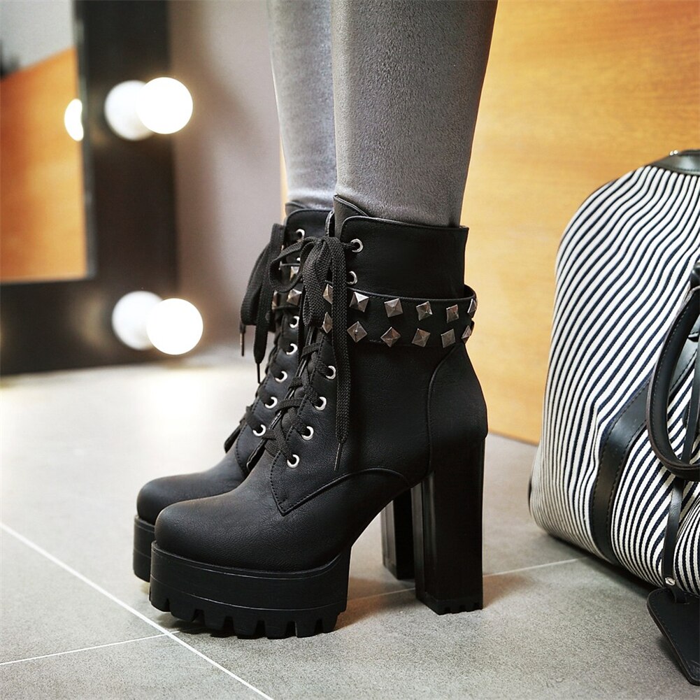 High-heeled black motorcycle boots with studs and laces, perfect for a daring winter biker look.