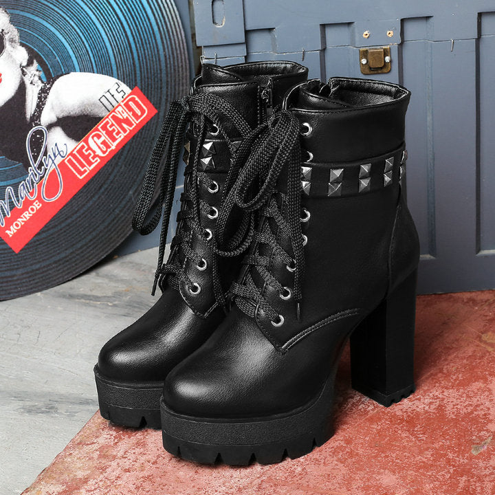 Stylish women's high heel boots in black with rivets and laces, perfect for a winter biker look.