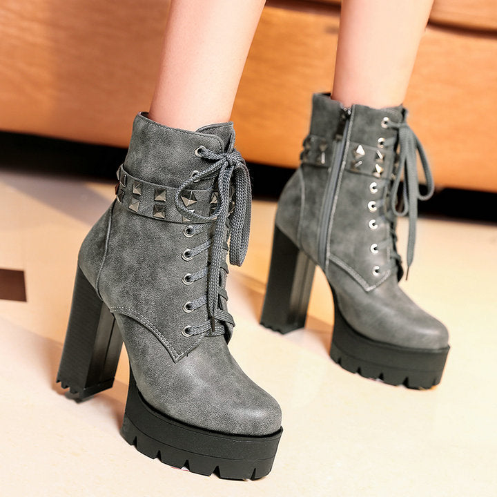 Stylish gray high heel motorcycle boots with rivets and laces, perfect for a daring winter look.