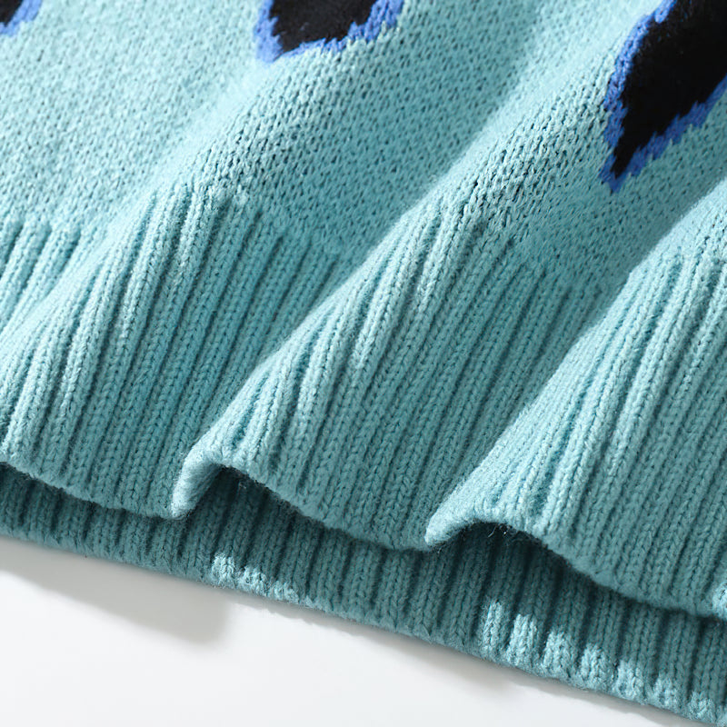 Close-up of a cool retro sweater featuring a blue flame pattern with ribbed cuffs for warmth and comfort.