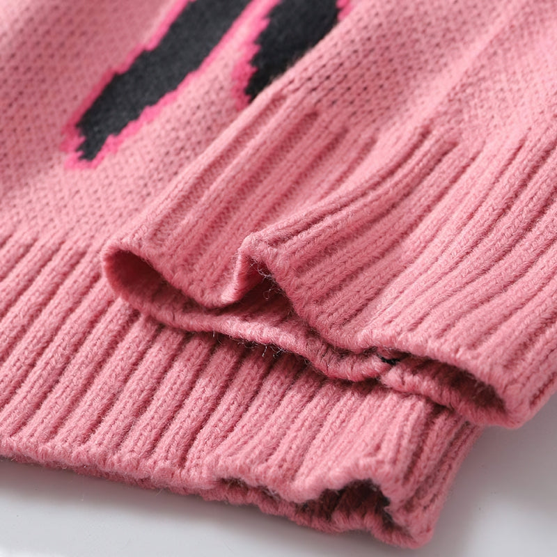 Close-up of the soft pink ribbed cuffs of a trendy retro sweater with flame pattern details.