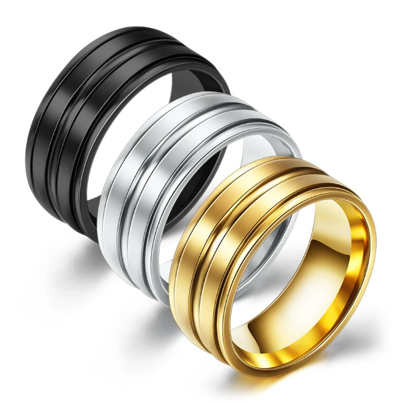 Three cool stainless steel unisex rings in black, silver, and gold with polished contrasting patterns.