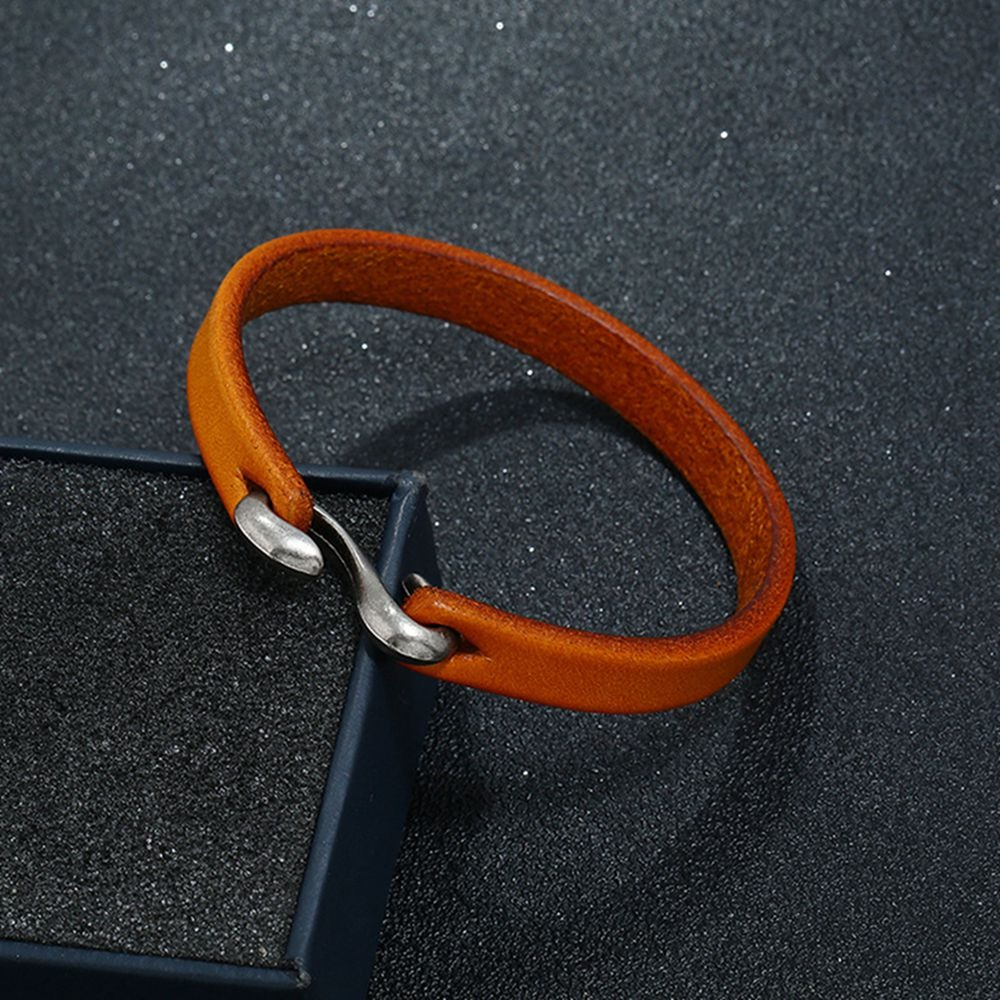 Cool unisex genuine leather narrow bracelet in vibrant orange with a sleek metal clasp on a dark background.