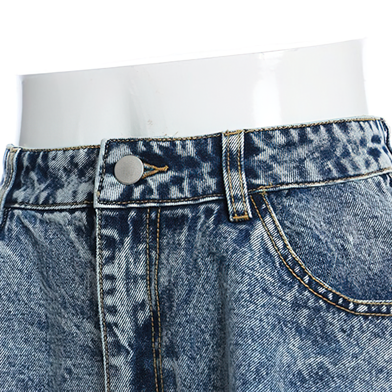 Close-up of trendy women's high waist denim mini shorts featuring button closure and detailed ruffles.