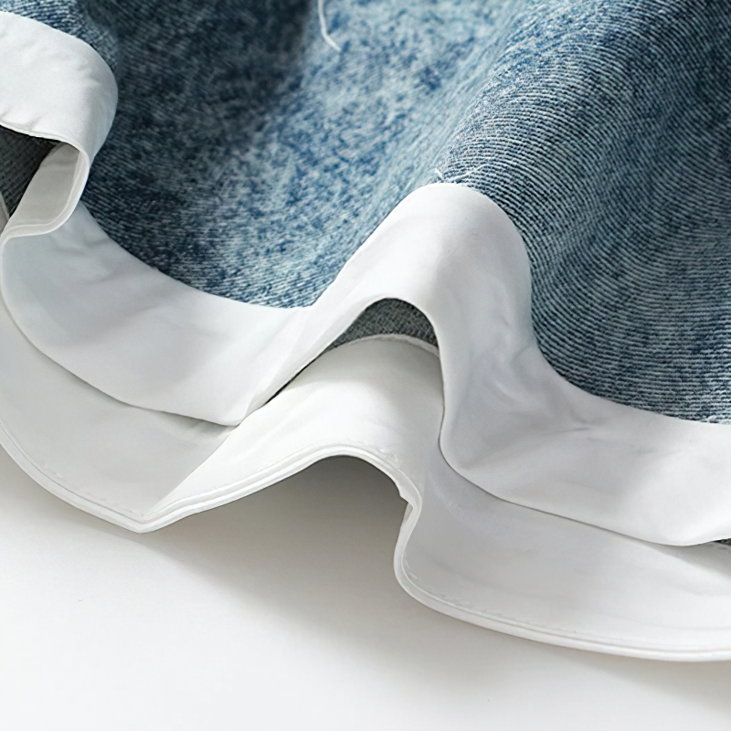 Close-up of cool women's denim mini shorts featuring stylish ruffle edges and a soft, breathable fabric.