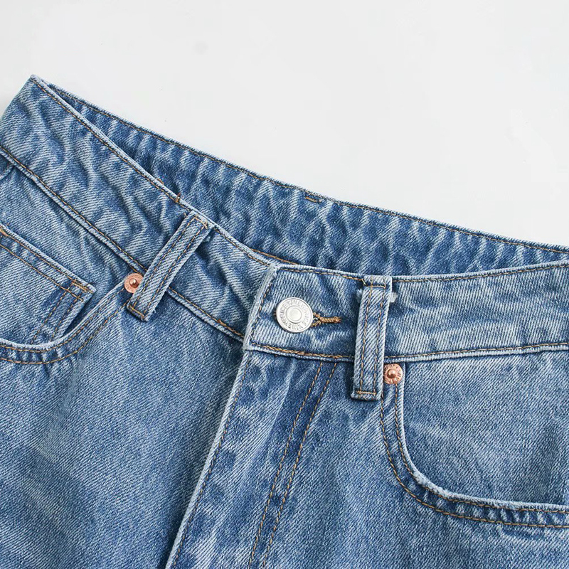 Close-up of high-waist denim jeans featuring button and zipper detail, showcasing trendy wide-leg style and pockets.