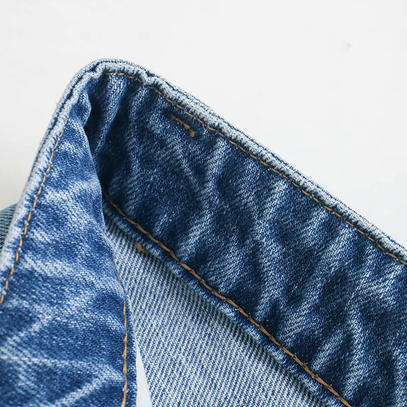 Close-up of the waistband of high waist wide leg denim pants, showcasing stylish stitching and soft fabric texture.