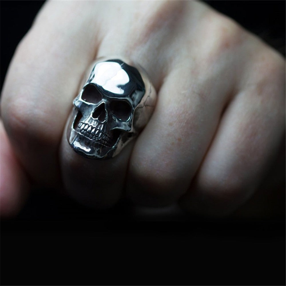 Silver skull ring on a hand, showcasing a cool gothic style accessory for rock lovers.