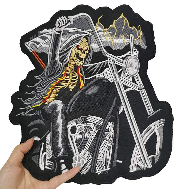 Creepy embroidered skull riding a motorcycle iron-on patch for jackets and bags.