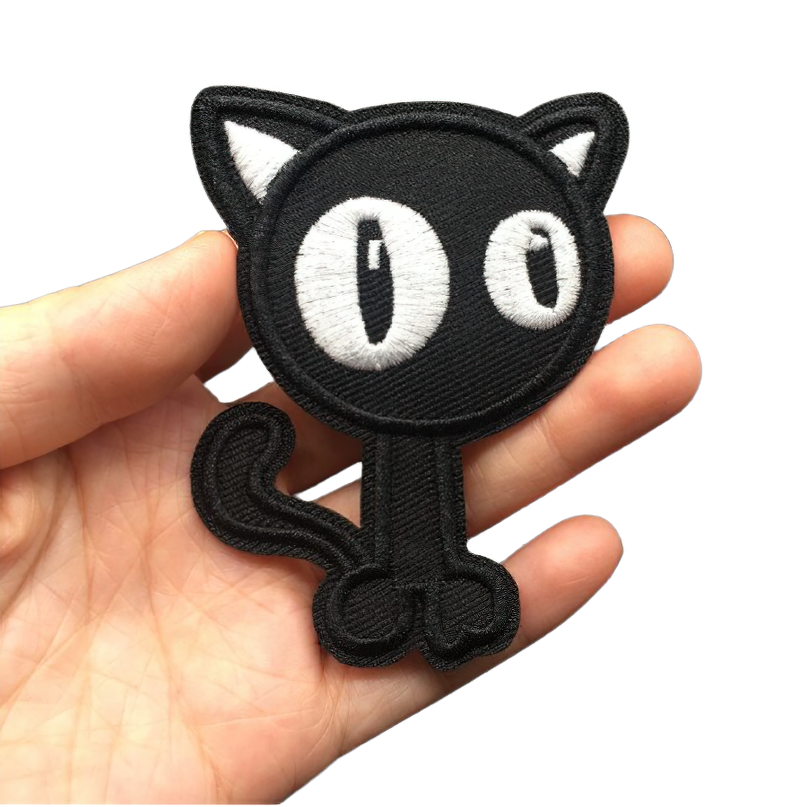 Cute black cat patch for clothing held in hand, perfect for alternative fashion lovers.