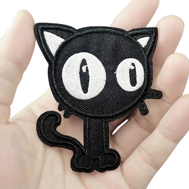 Cute black cat patch held in hand, perfect for trendy outfits and alternative fashion lovers.