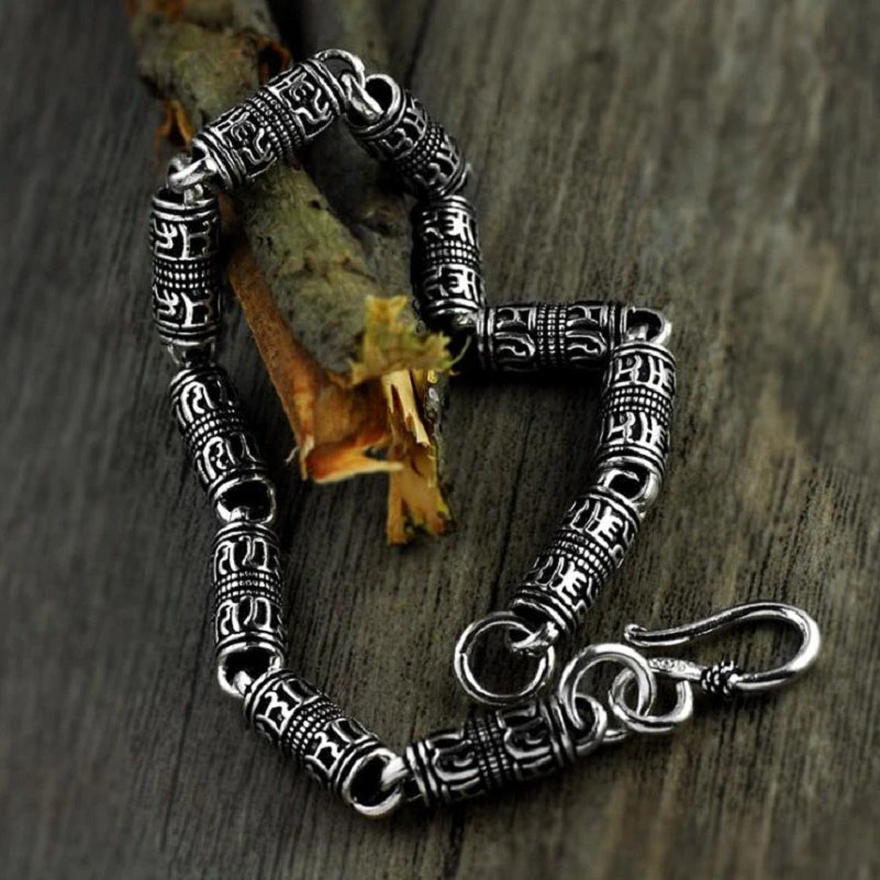 Cylindrical silver bracelet with engraved symbols for men and women, showcasing ethnic jewelry style.