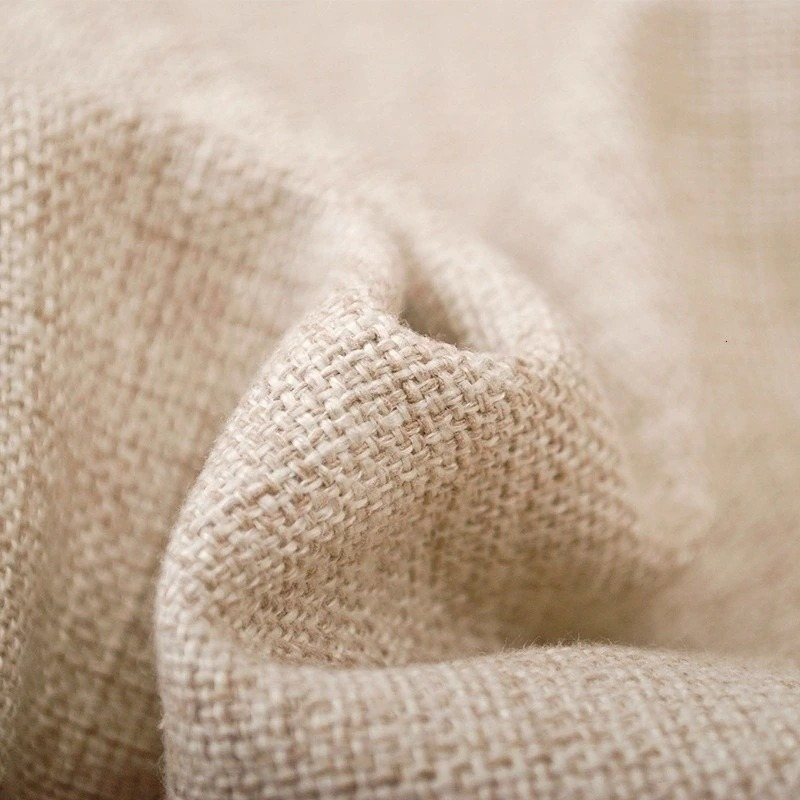 Close-up of textured beige linen fabric showcasing its natural weave and softness, perfect for home decor.