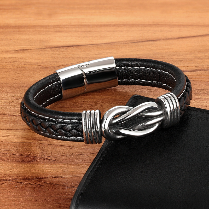 Deluxe men's leather bracelet with stainless steel clasp, featuring an irregular graphic design, laid on a wooden surface.
