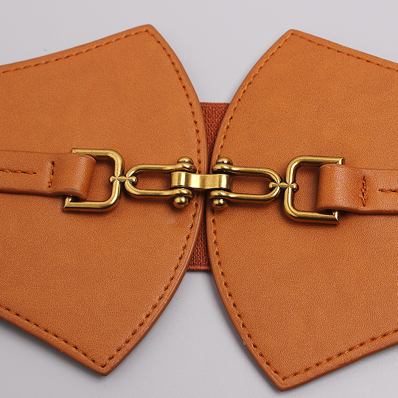 Close-up of a designer PU leather wide belt with a gold metal buckle, showcasing vintage corset style.