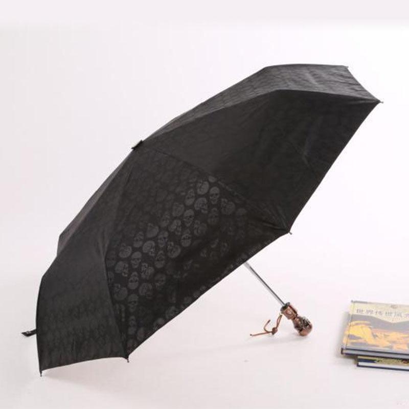 Devil skull handle umbrella with black skull pattern, three-folding, fully automatic, stylish rain gear for unisex.