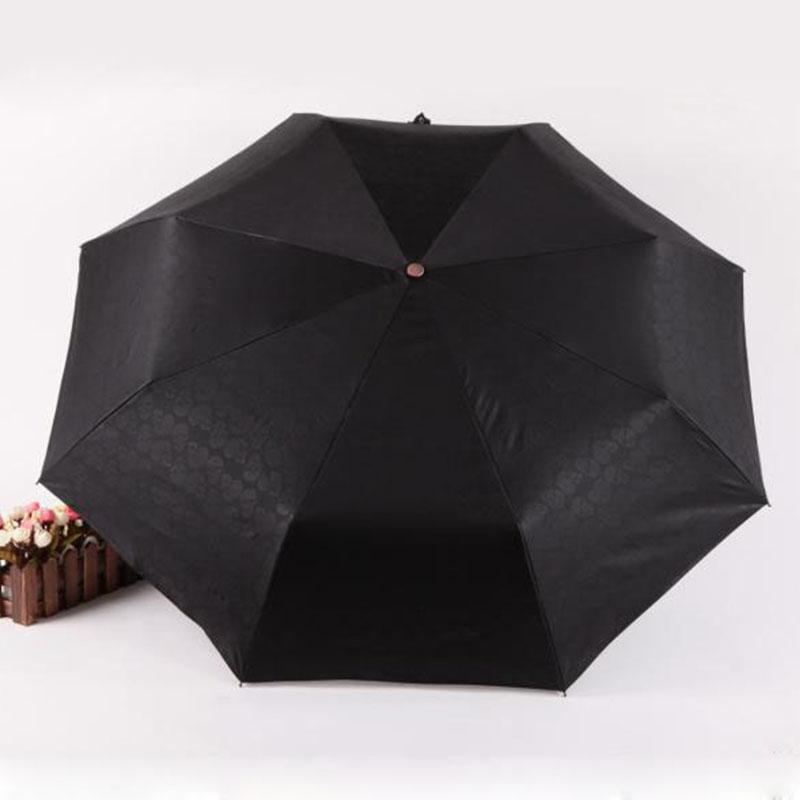 Black fully-automatic three-folding umbrella with stylish design and UV protection.