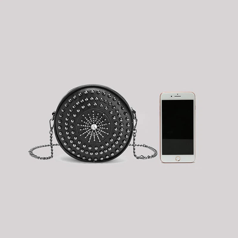 Stylish women's circular bag with diamond decor and adjustable chain strap, next to a smartphone for size reference.