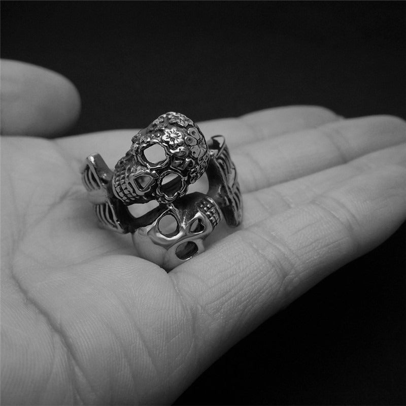 Double skull stainless steel ring on a hand, showcasing unique design for rocker and biker jewelry.