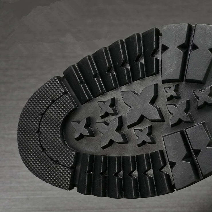 Close-up of the rugged sole of stylish men's motorcycle boots, showcasing its durable traction design.