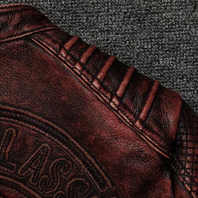 Close-up of the textured shoulder area of a durable brown biker jacket with stitching details.